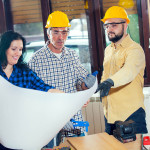 Three construction workers reviewing building plans.
